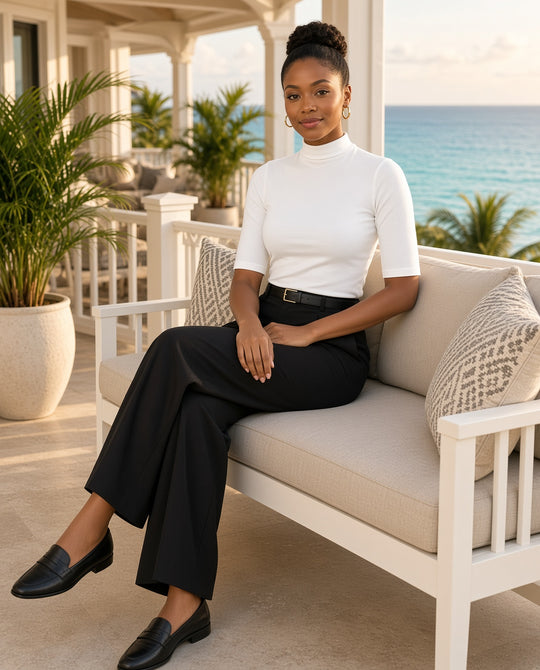 Model wearing the white Mock-Neck Elbow-Sleeve Tee on an oceanfront lanai