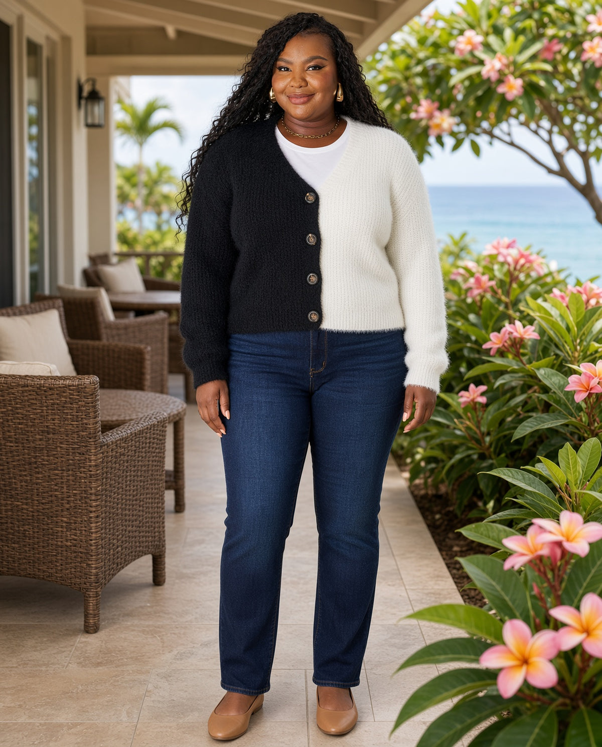 Model wearing the Two-Tone Button-Front V-Neck Cardigan in black and white with dark jeans on a garden terrace
