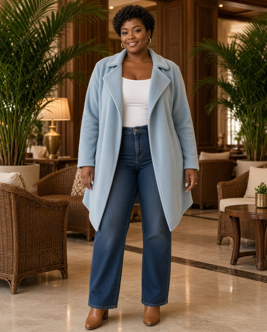 Model wearing the Fleece Waterfall-Collar Jacket in light blue with jeans in a resort lobby